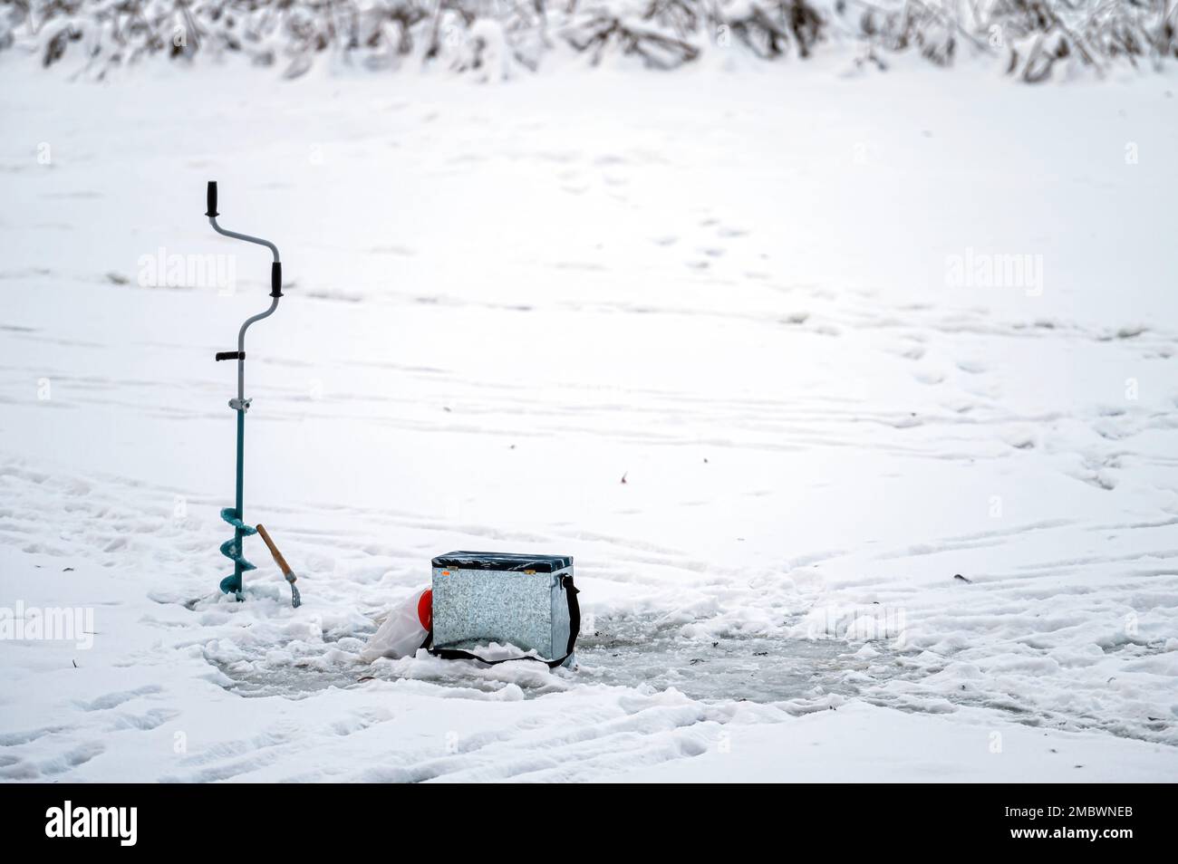 Équipement de pêche pour la pêche sous la glace d'hiver sur le fond d'une rivière gelée. Pêche sous la glace. Banque D'Images