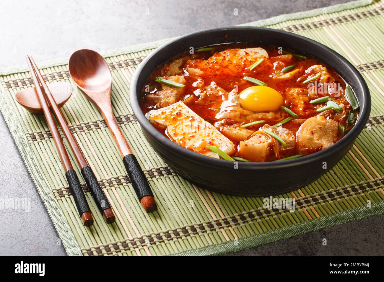 Ragoût de tofu doux épicé avec kimchi et poitrine de porc sur le bol de la table. Horizontale Banque D'Images