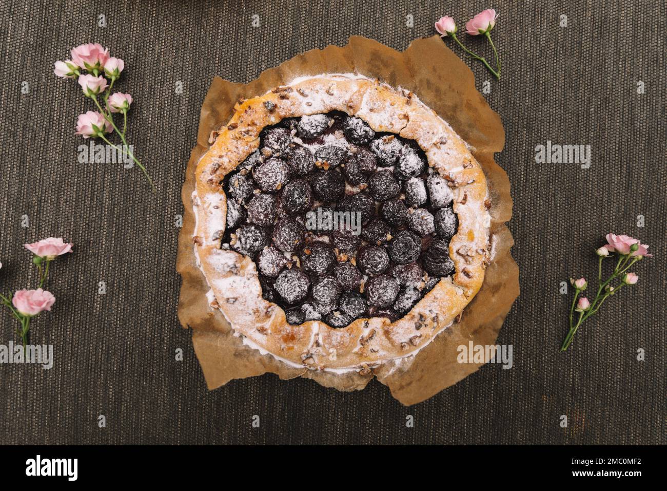 Tarte aux prunes maison aux raisins secs sur fond de bois. Banque D'Images