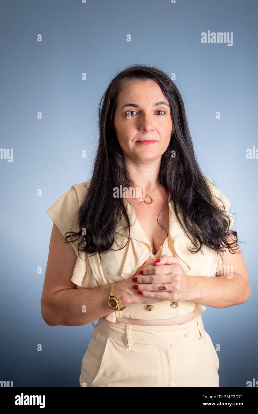 Jeune belle femme avec les mains ensemble, confiant, gai. Isolé sur fond gris clair. Banque D'Images