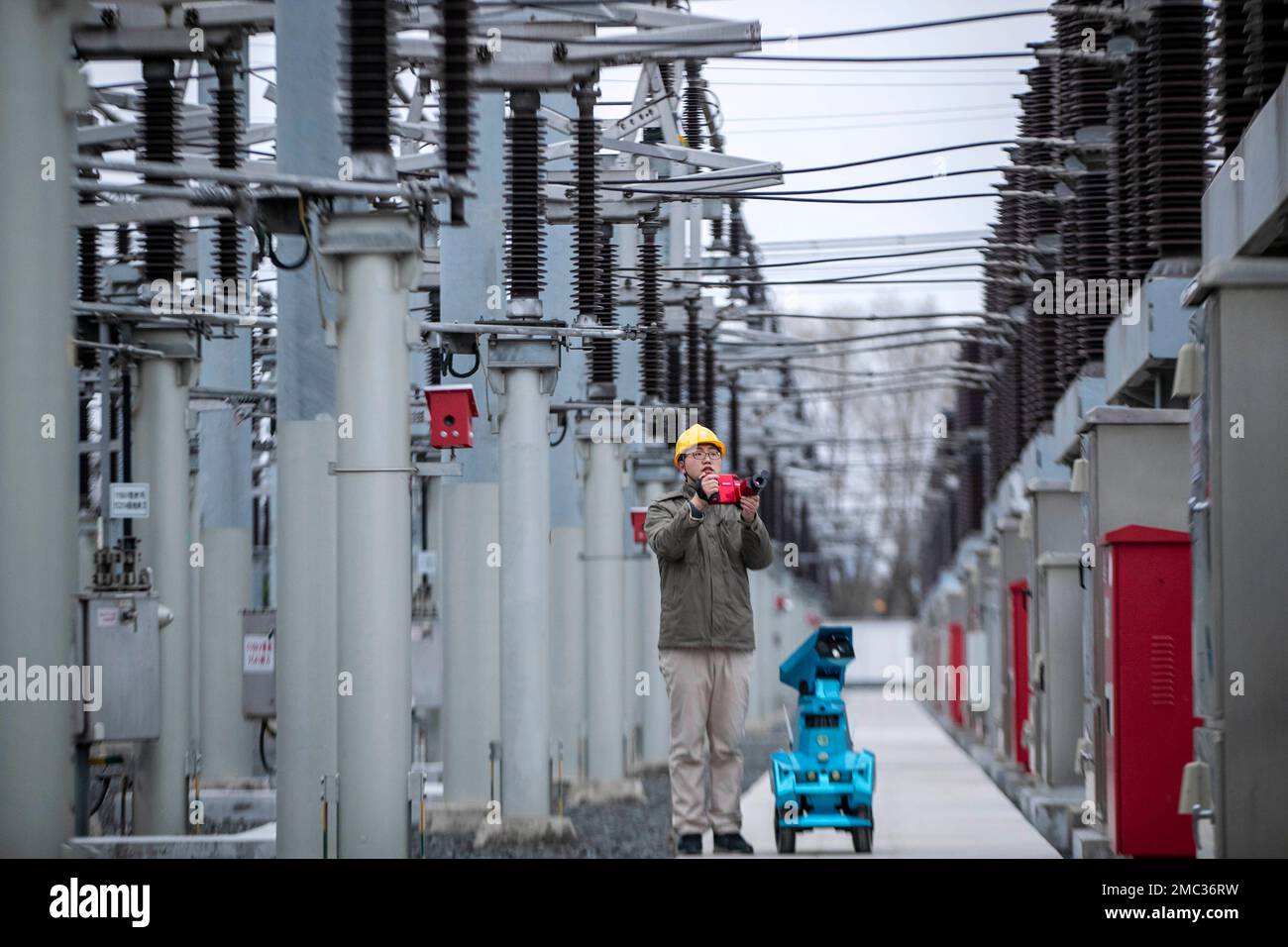 TAIZHOU, CHINE - 21 JANVIER 2023 - Un membre du personnel en service inspecte le fonctionnement de l'équipement de sous-station avec un robot d'inspection intelligent au Banque D'Images