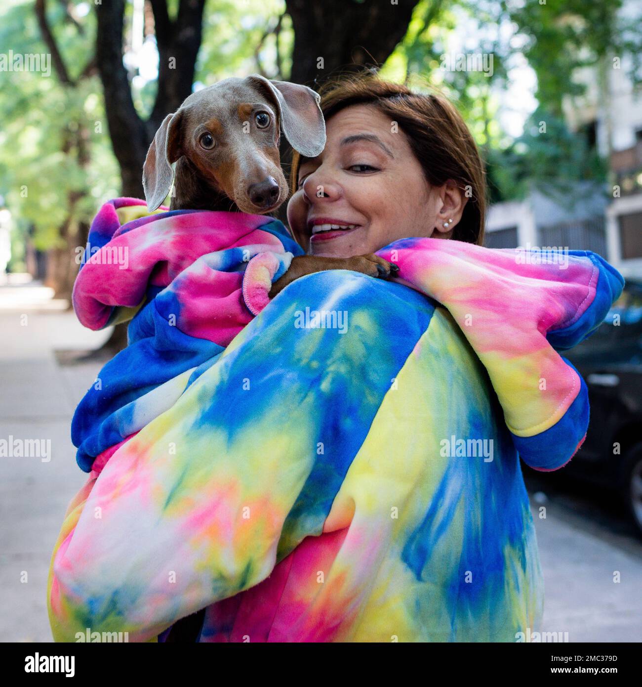 Femme latine tenant son chien. Les deux sont habillés comme l'appareil photo. Banque D'Images