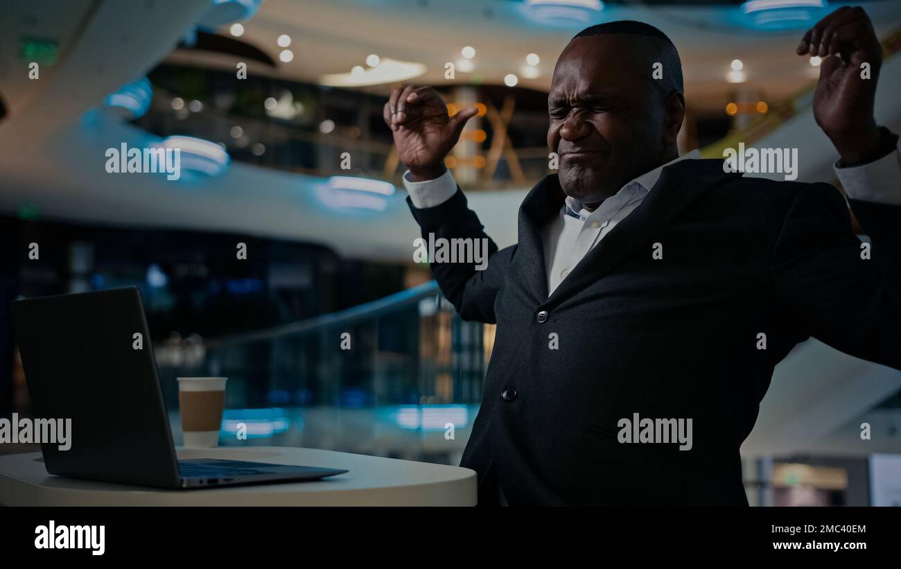 Afro-américain adulte homme d'affaires d'âge moyen indépendant travaillant avec ordinateur dans bureau entreprise café navigation dactylographiant ordinateur portable sentiment de retour Banque D'Images