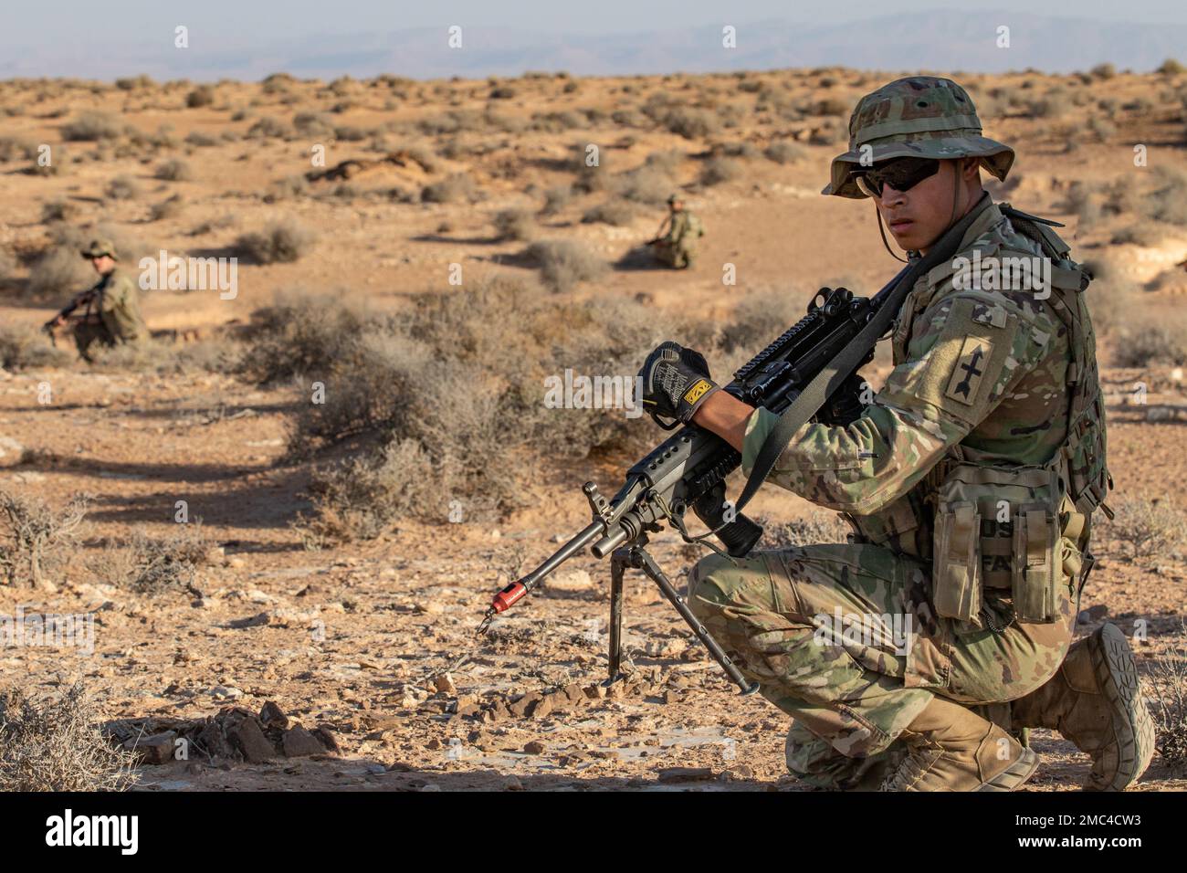 ÉTATS-UNIS Jerry Mejia, un tireur d'armes automatiques de l'armée, Bravo Company, 3rd Bataillon, 126th Infantry Regiment, Michigan National Guard, Prend un genou tout en recevant les ordres de son chef d'équipe lors d'un exercice d'entraînement simulé de Lion africain 22 dans la zone d'entraînement de Ben Ghilouf en Tunisie, 24 juin 2022. AL22 correspond aux États-Unis L'exercice annuel le plus important, le plus important, conjoint, du Commandement de l'Afrique organisé par le Maroc, le Ghana, le Sénégal et la Tunisie, 6 juin - 30. Plus de 7 500 participants de 28 pays et de l'OTAN s'entraînent ensemble en mettant l'accent sur l'amélioration de la préparation des forces américaines et des forces nationales partenaires. AL22 est un j Banque D'Images