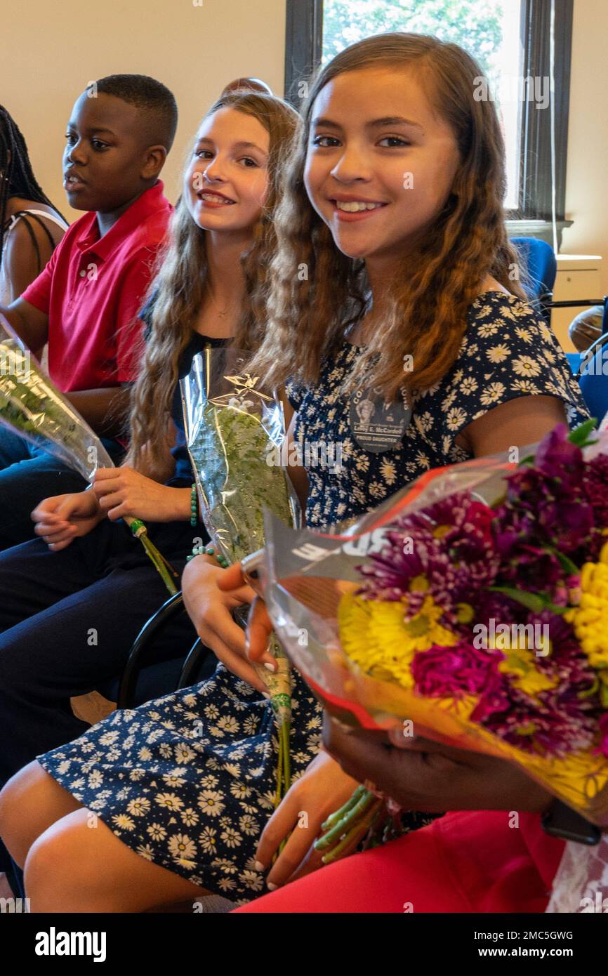 Les filles du Sgt. Principal Leroy E. McCardell Jr. Sourient après avoir reçu des fleurs de leur père lors de sa cérémonie de retraite, 25 juin 2022, à la base de la Garde nationale aérienne Jefferson Barracks, St. Louis, Missouri. Leur père a servi pendant 34 ans. Banque D'Images