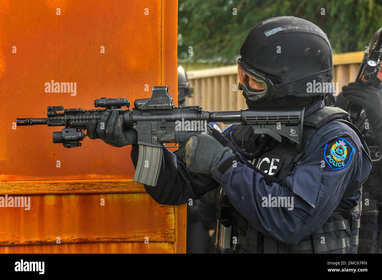 Un officier du Groupe d'intervention tactique en uniforme et masqué qui vise son arme. Banque D'Images