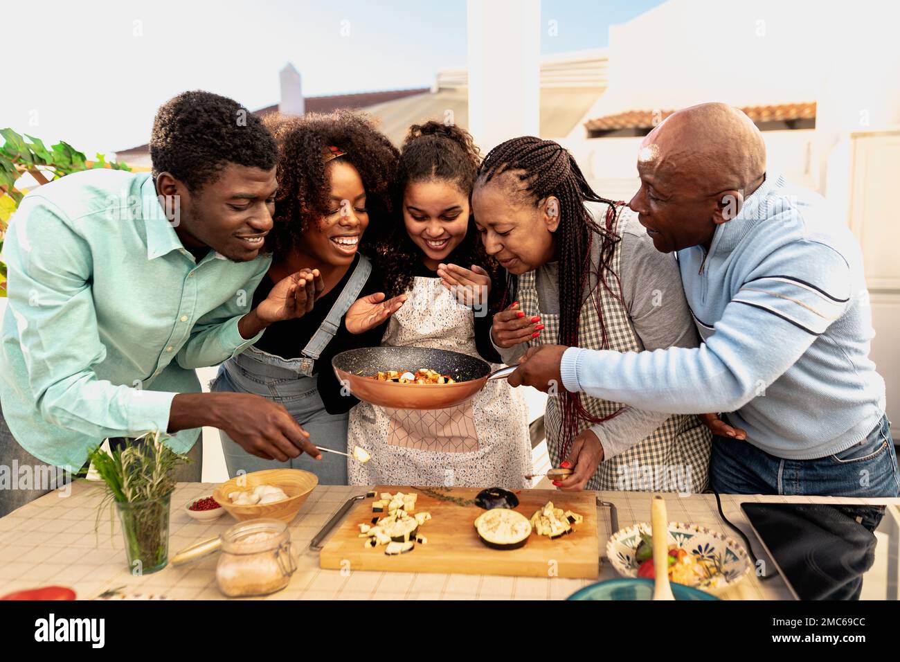 Une famille africaine heureuse prépare une recette sur le patio de la maison Banque D'Images