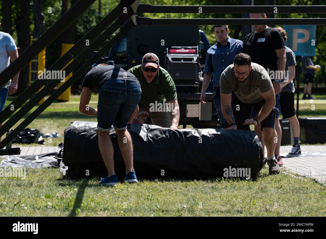 ÉTATS-UNIS Le Sgt Brent Kenney, maître principal de la Force aérienne, du surintendant des réparations lourdes (au centre) du 52nd Escadron du génie civil, dirige les bénévoles dans la mise en place du système du projet Arcwater à Otlock, en Pologne, en 26 juin 2022. Arcwater peut entièrement fournir une tente avec de l'énergie, des téléviseurs en fonctionnement, un système de climatisation et plus principalement en utilisant l'énergie solaire. Banque D'Images