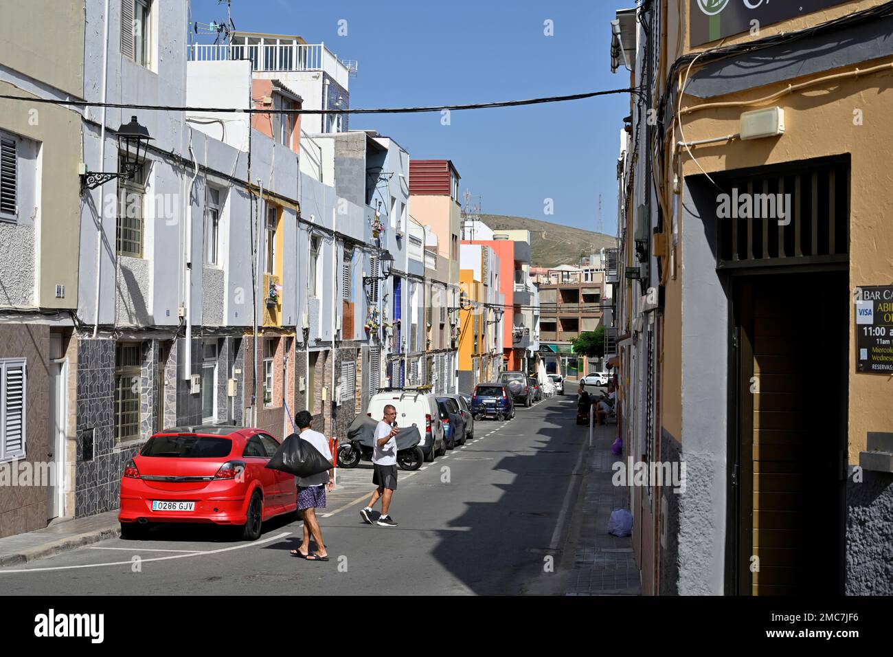 Rue résidentielle avec des maisons et des appartements mitoyens près de la chaussée étroite dans la ville d'Arguineguín, Gran Canaria, îles Canaries Banque D'Images