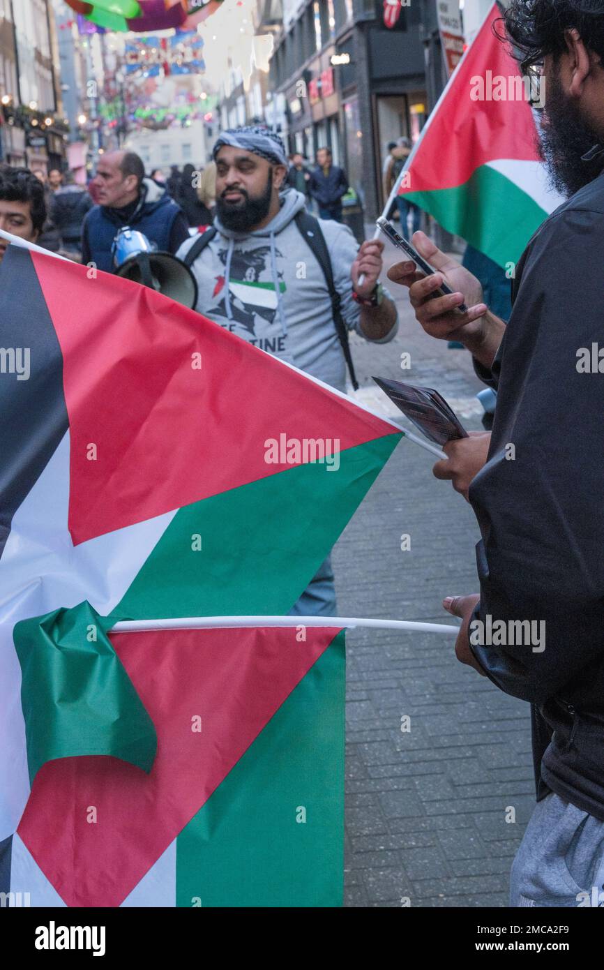 Londres, Royaume-Uni. 21 janvier 2023. Un contre-manifestant s'entretient avec un membre du réseau juif pour la Palestine. Les manifestants du magasin phare de Puma, Carnaby St, exigent que le PUMA cesse d'ignorer les équipes sportives palestiniennes et mette fin à son parrainage de l'Association israélienne de football, qui comprend des équipes dans des colonies israéliennes illégales sur des terres palestiniennes volées. La manifestation de la campagne de solidarité palestinienne au Royaume-Uni a été opposée par un petit groupe avec des drapeaux israéliens. Les manifestations à l'extérieur des magasins Puma et des revendeurs à travers le Royaume-Uni ont fait partie d'un boycott mondial. Peter Marshall/Alay Live News Banque D'Images