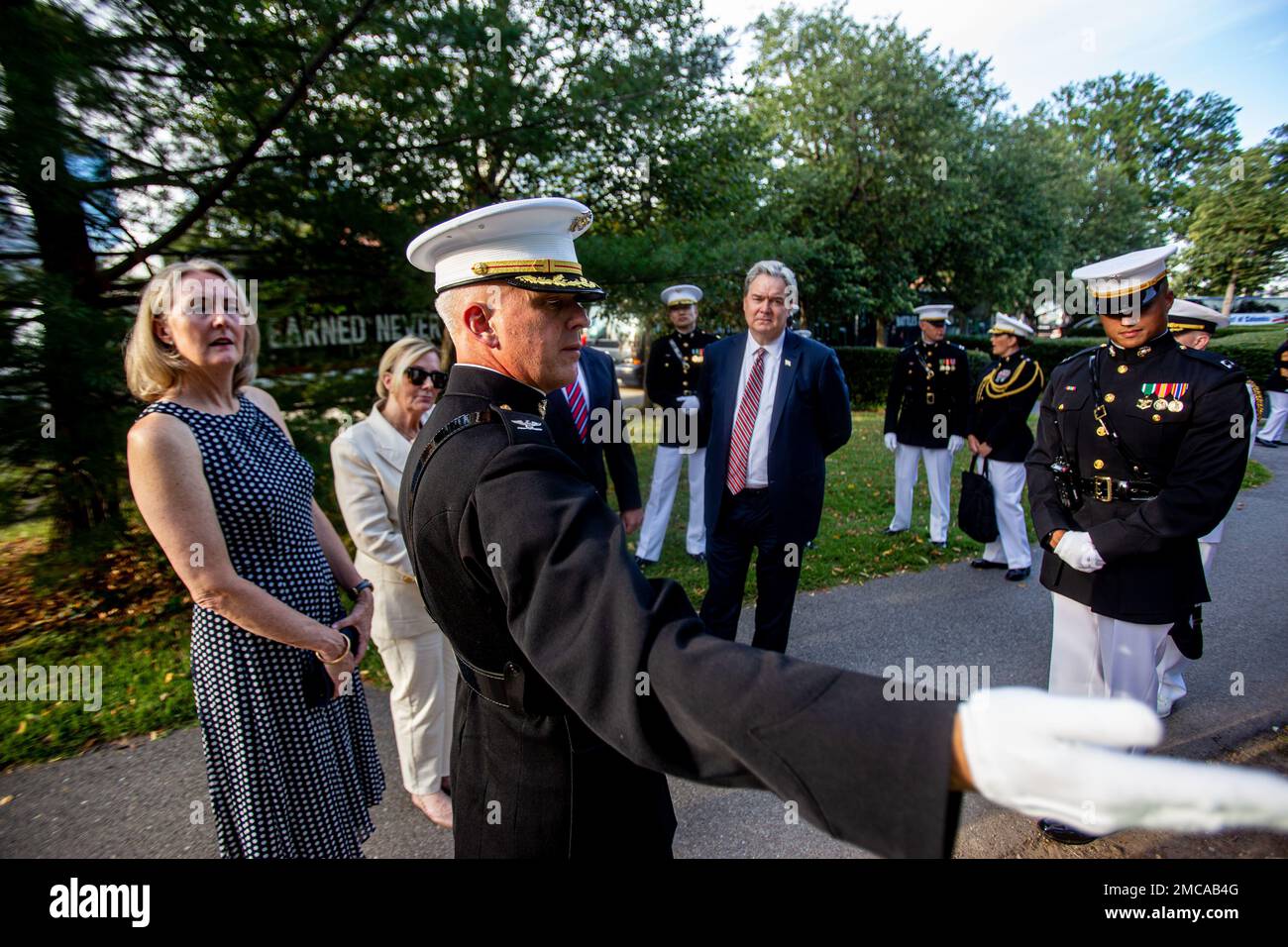 Le colonel Robert A. Sucher, commandant de la caserne marine de Washington,  présente un briefing à l'invité d'honneur et au responsable de l'accueil  avant une parade au coucher du soleil au Monument
