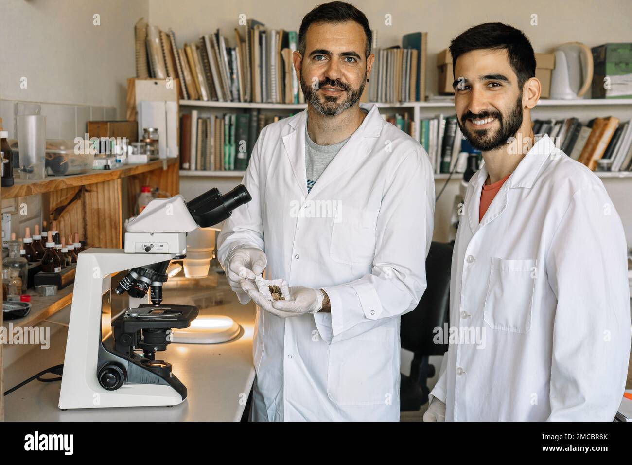 Deux scientifiques étudient le matériel de champignons séchés au microscope en laboratoire. Travail d'équipe. Projets de recherche. Banque D'Images