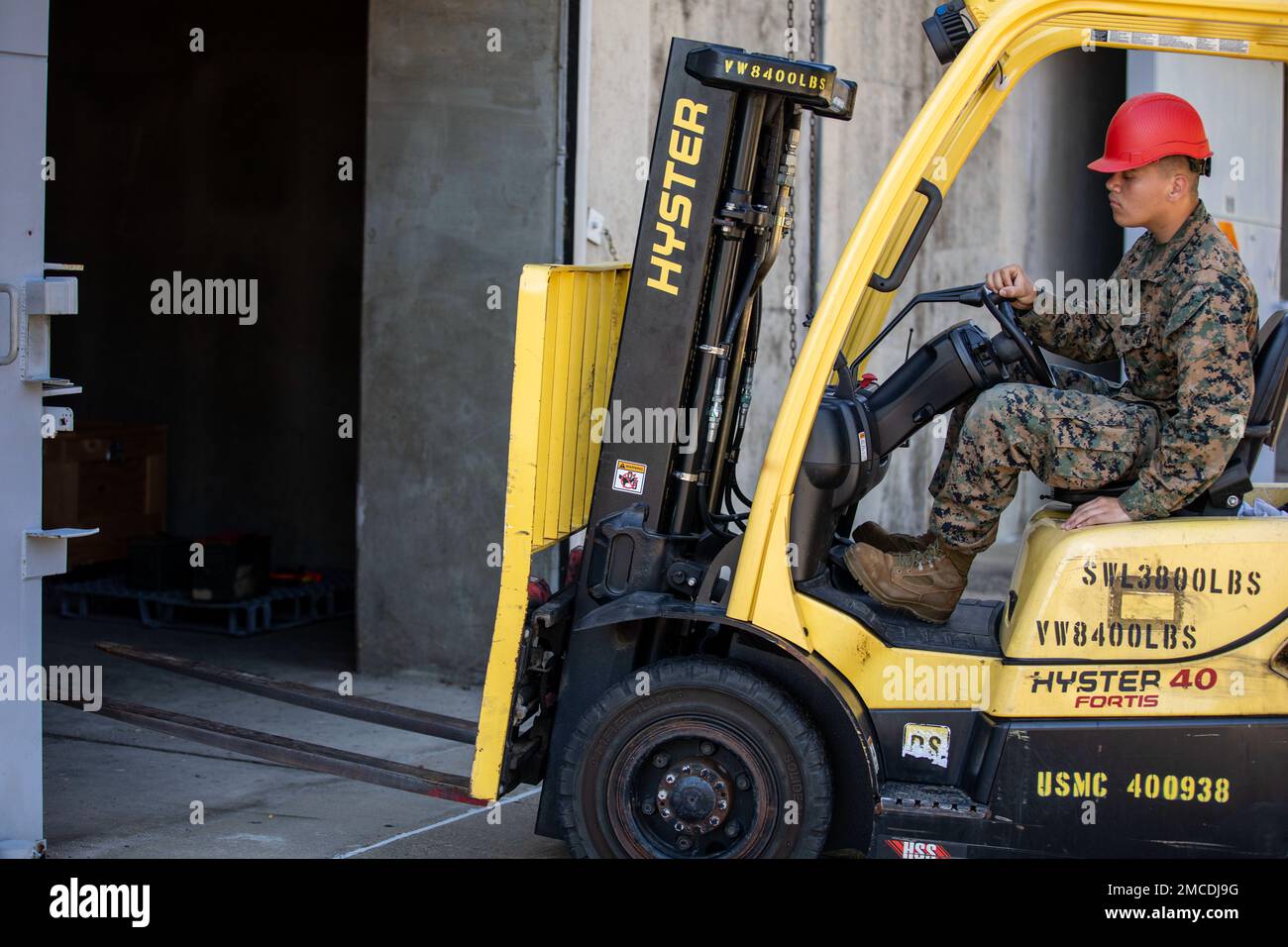 ÉTATS-UNIS Caporal Oscar Morales-Nunes, technicien en munitions, point d’approvisionnement en munitions, Bataillon de sécurité, de Bluffton, corps maritime Caroline du Sud, exploite un chariot élévateur près d'un magazine Earth Covered Magazine (ECM) sur la base du corps de Marine (MCB) Quantico, Virginie, 30 juin 2022. L'ECM est une installation de stockage de munitions qui ressemble à une grande colline herbeuse avec une grande porte coulissante. Chaque ECM reçoit un poids explosif net et peut contenir une variété de munitions et d'explosifs. Banque D'Images