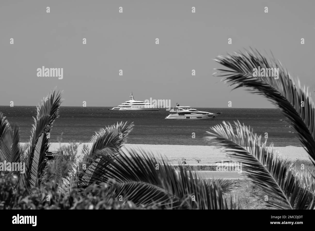 IOS, Grèce - 4 juin 2001 : vue de deux beaux yachts sur la célèbre plage de Mylopotas à iOS Grèce en noir et blanc Banque D'Images