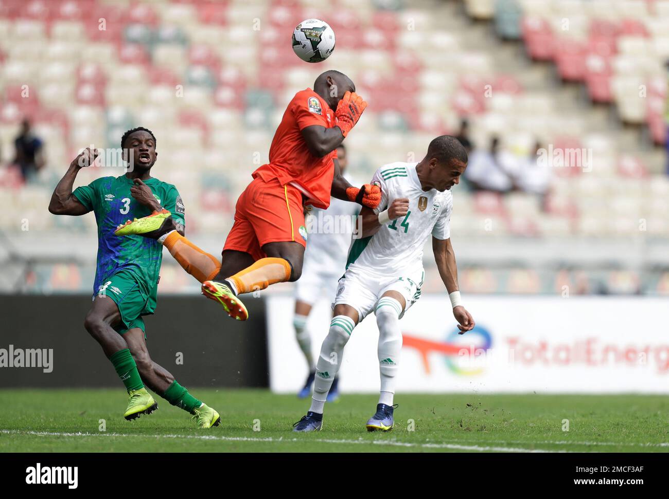 Sierra Leone's goalkeeper Mohamed Kamara, center, heads the ball past  Algeria's Sofiane Bendebka, right, during the African Cup of Nations 2022  group E soccer match between Algeria and Sierra Leone at the