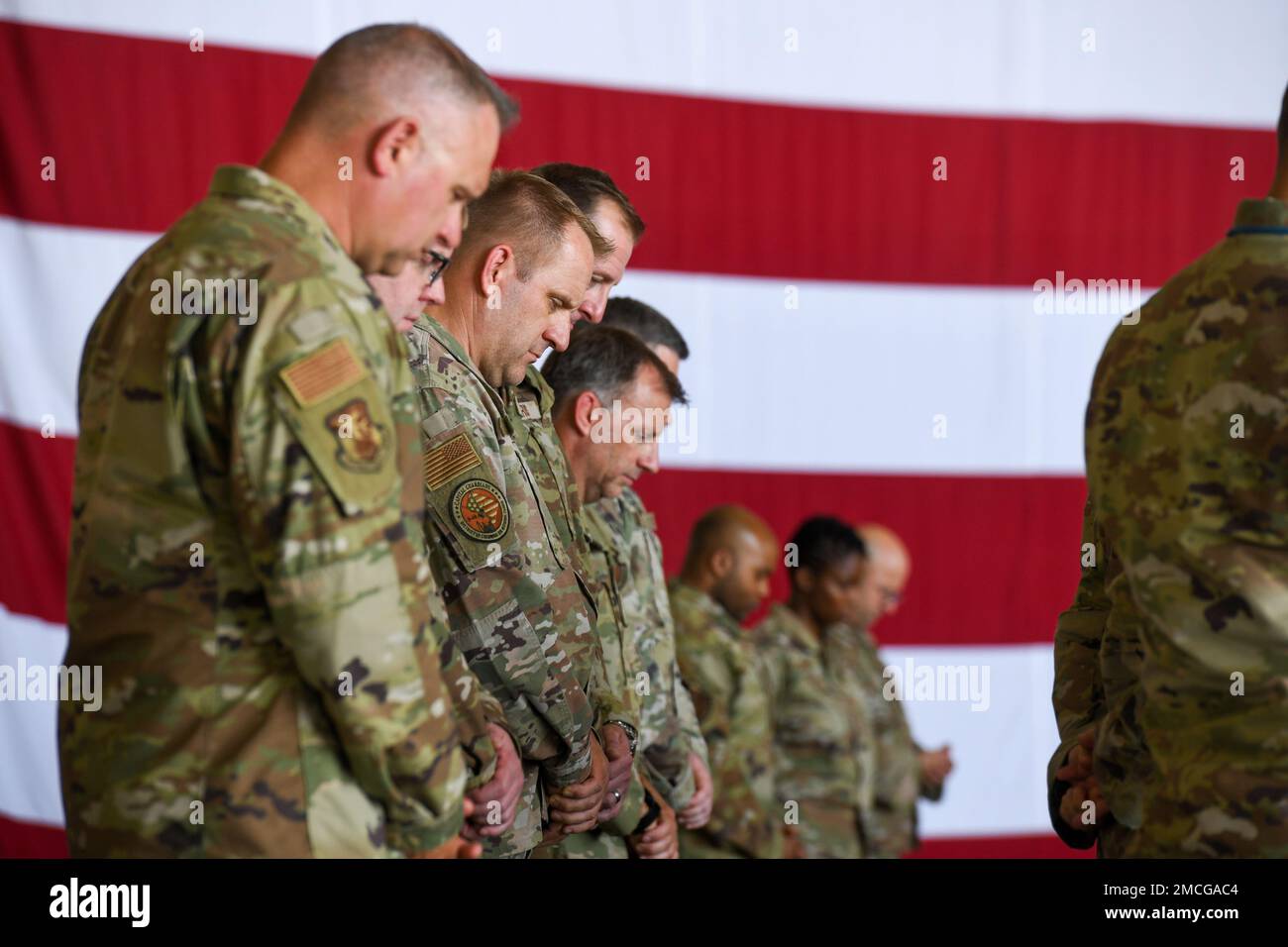 Les membres de la 113th Escadre, Garde nationale aérienne du district de Columbia, se sont inclinés la tête en reconnaissance d'une invocation de prière prononcée lors d'une cérémonie de promotion sur 1 juillet 2022, dans un hangar sur la base interarmées Andrews, Marie. Banque D'Images