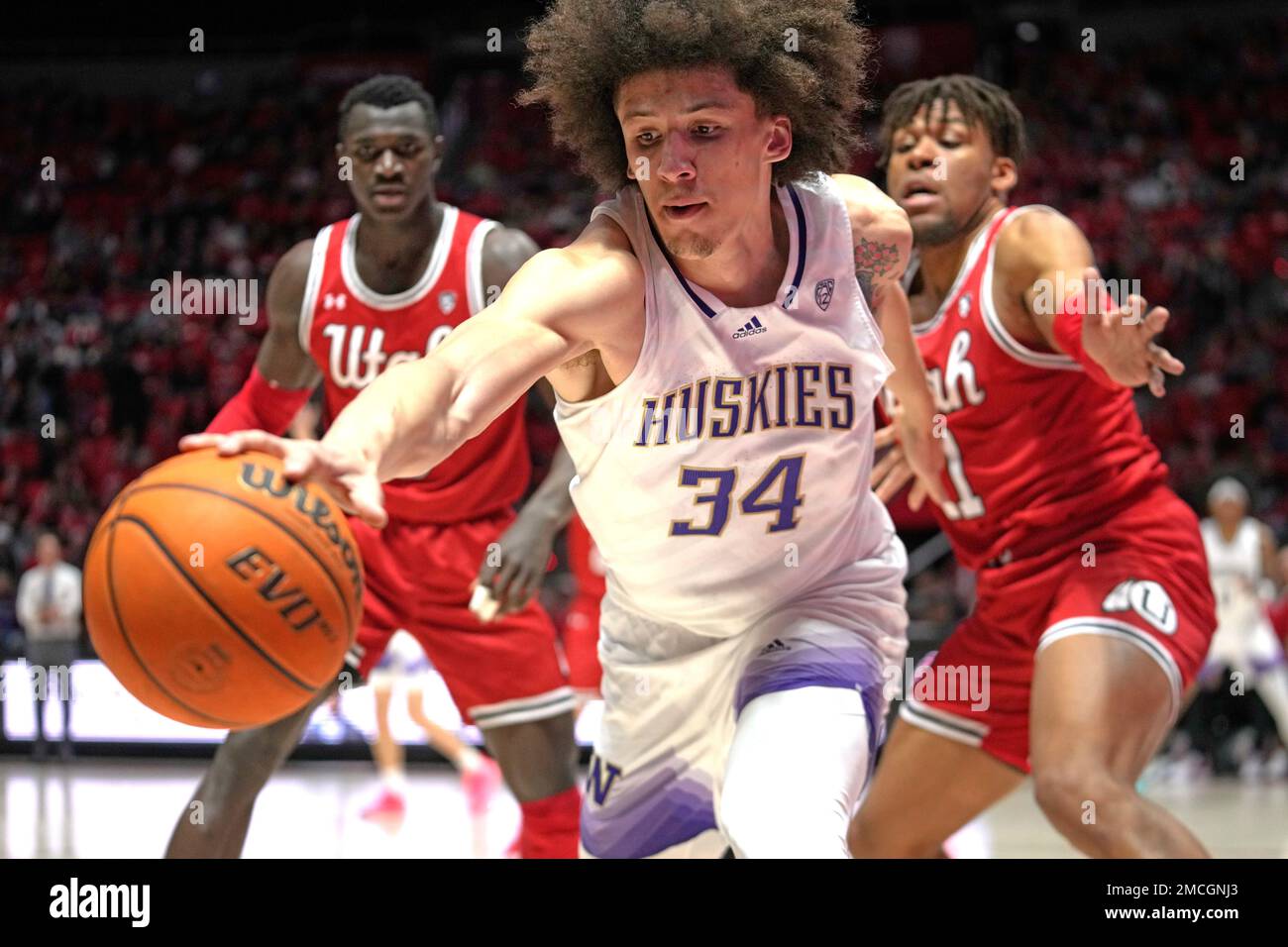 Washington center Braxton Meah (34) goes after the ball as Utah's Keba  Keita, left, and Wilguens Exacte Jr., right, look on during the first half  of an NCAA college basketball game Saturday,