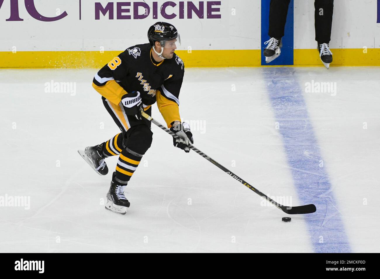 Pittsburgh Penguins defenseman Brian Dumoulin (8) carries the puck during the second period of an NHL hockey game against the Buffalo Sabres on Friday, Dec. 17, 2021, in Pittsburgh. (AP Photo/Fred Vuich) Banque D'Images