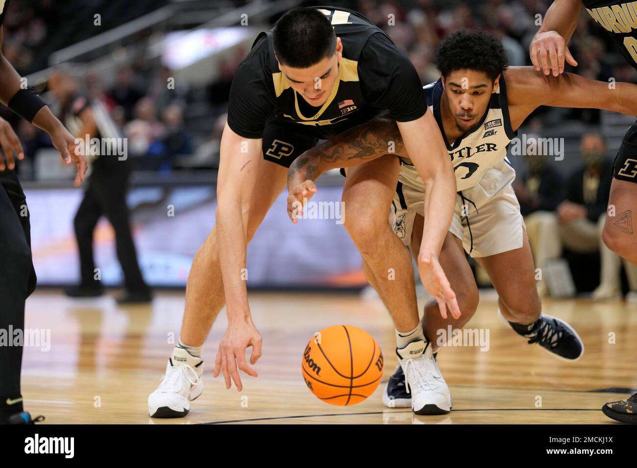 Purdue center Zach Edey fights for a loose ball with Butler forward D.J. Hughes, right, during the first half of an NCAA college basketball game, Saturday, Dec. 18, 2021, in Indianapolis. (AP Photo/AJ Mast) Banque D'Images