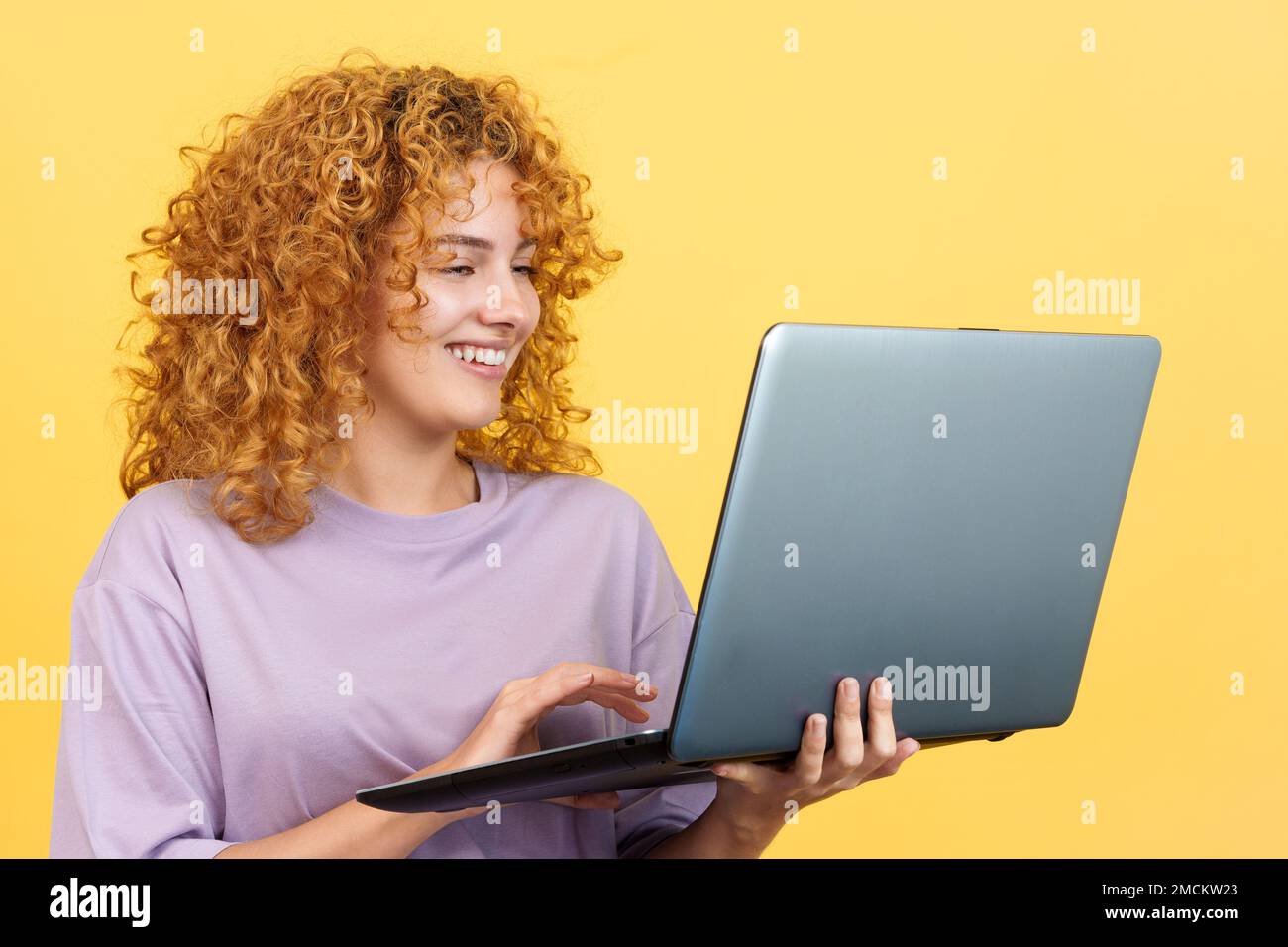 Femme souriante debout et utilisant un ordinateur portable Banque D'Images