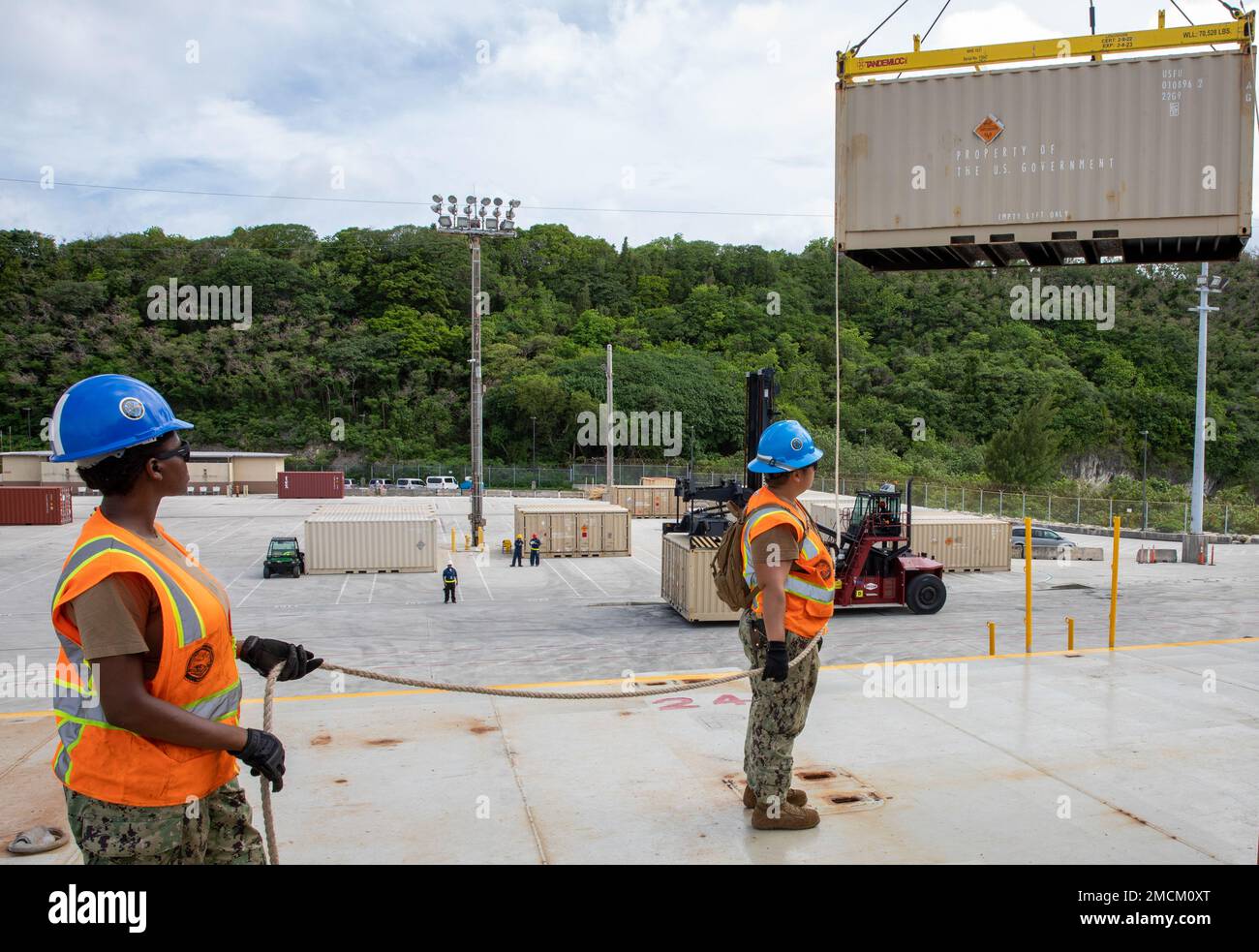 SANTA RITA, Guam (6 juillet 2022) les marins affectés au Groupe de travail 75,2 du commandant de la Force opérationnelle (FCT) 75, fournissent des services de manutention et de transport de marchandises de surface avec le Escadron de munitions 36th de la Force aérienne et le Commandement des munitions de la Marine Division de l’Asie du Pacifique-est (DMAE du NCPAC) Dans l'ascenseur sur et le levage de conteneurs ammo ISO à bord de MV Ocean Glory. Banque D'Images