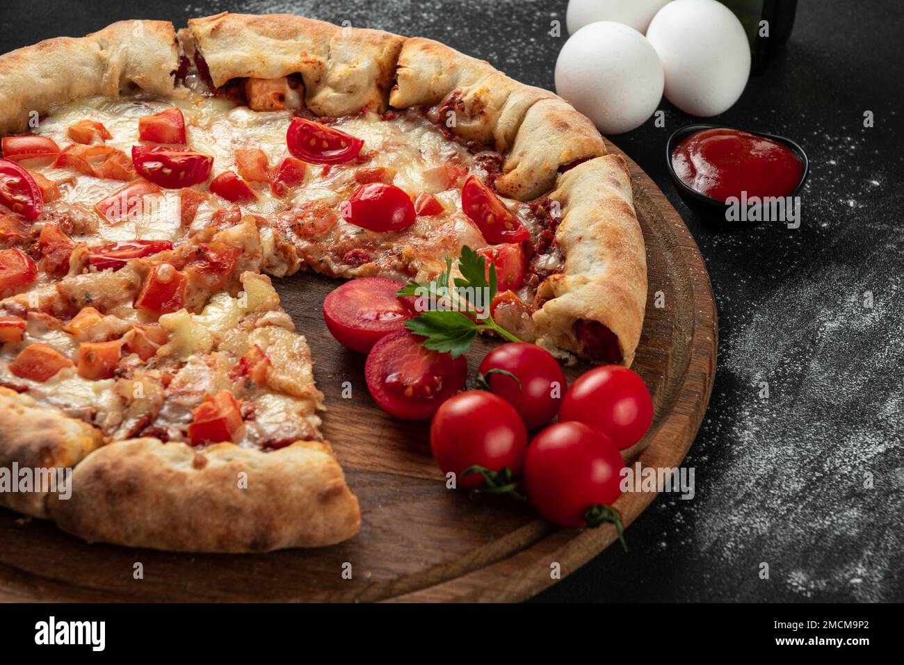 Pizza cuite avec ingrédients à côté de faire sauce tomate, mozzarella, tomates, huile d'olive, fromage, épices, servies sur une table rustique en bois. Forme plate Banque D'Images