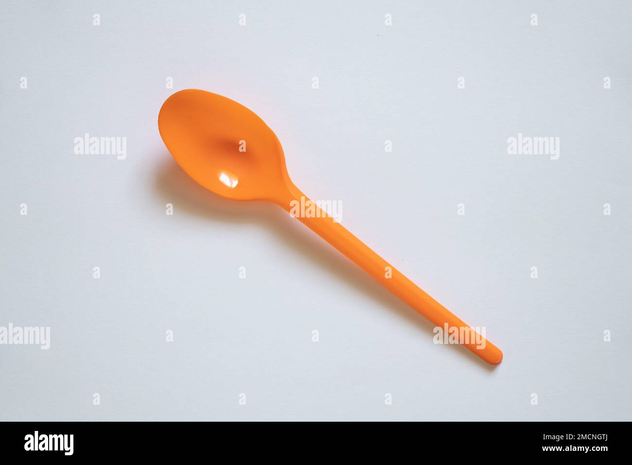 cuillère en plastique orange sur fond blanc, cuillère Banque D'Images