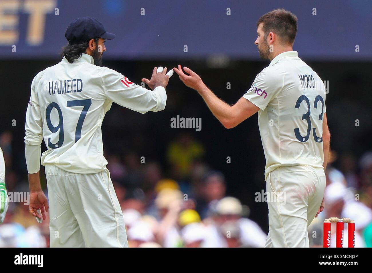 England's Mark Wood, right, is congratulated by teammate Haseeb Hameed after dismissing Australia's Nathan Lyon during day three of the first Ashes cricket test at the Gabba in Brisbane, Australia, Friday, Dec. 10, 2021. (AP Photo/Tertius Pickard) Banque D'Images