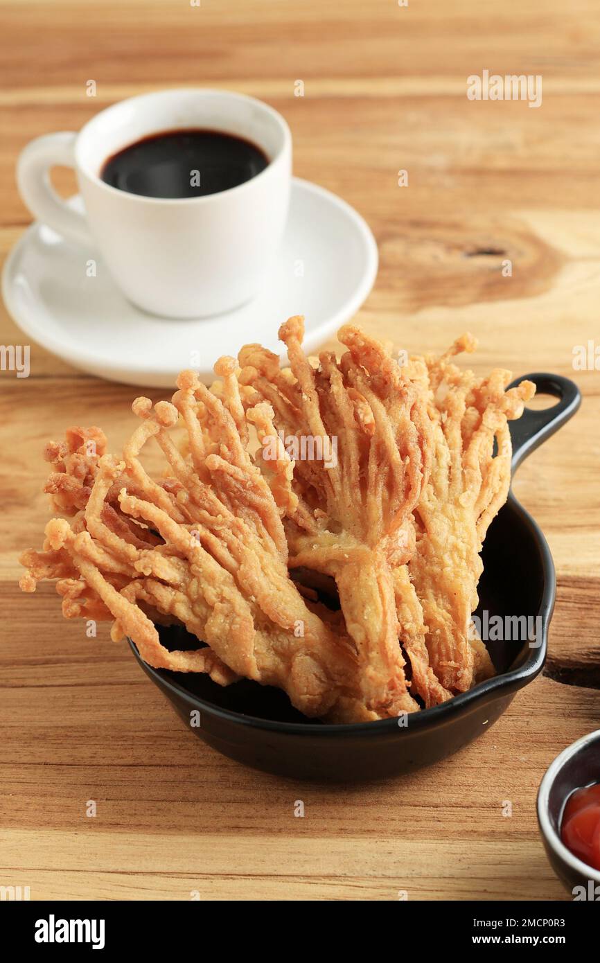 Champignons Enoki frits ou champignons Golden Needle avec sauce piquante et café noir, cuisine végétarienne Banque D'Images