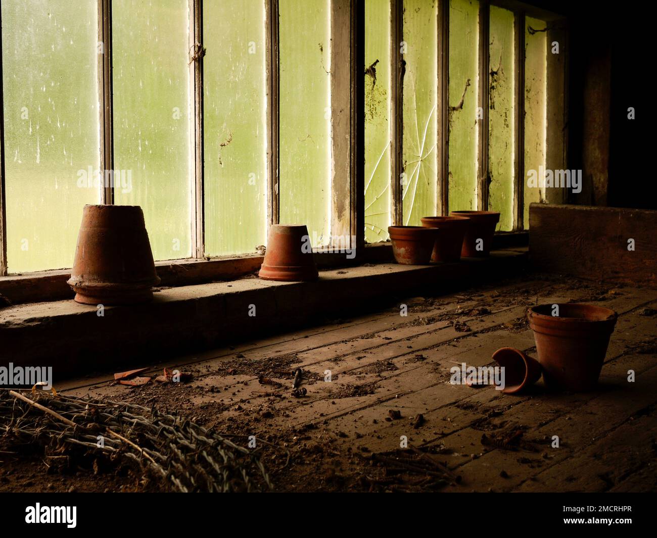 Une image d'ambiance de pots de terre cuite poussiéreux dans un ancien hangar de pot abandonné avec des fenêtres cassées Banque D'Images