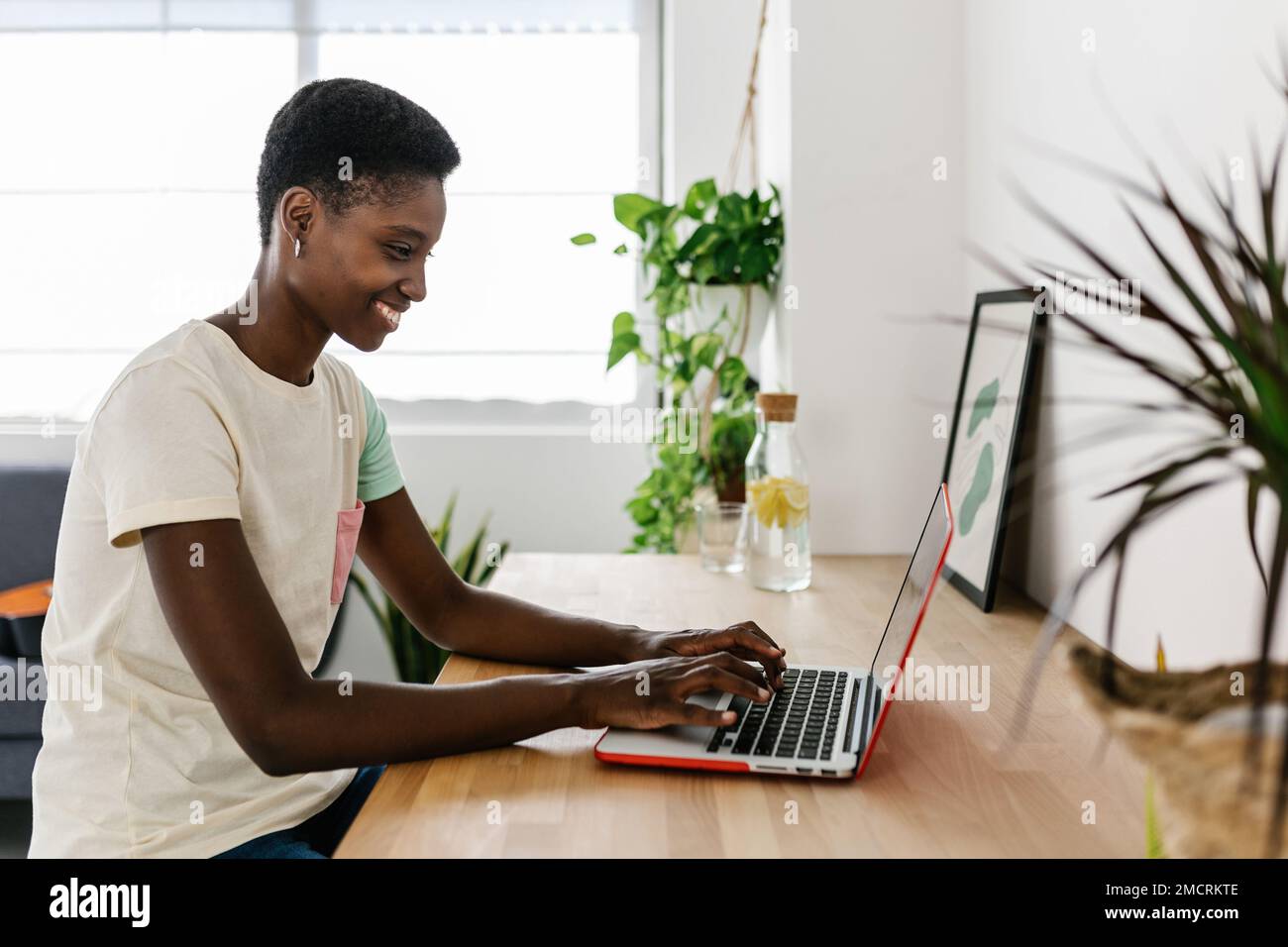 Jeune femme noire travaillant à distance à la maison à l'aide d'un ordinateur portable Banque D'Images