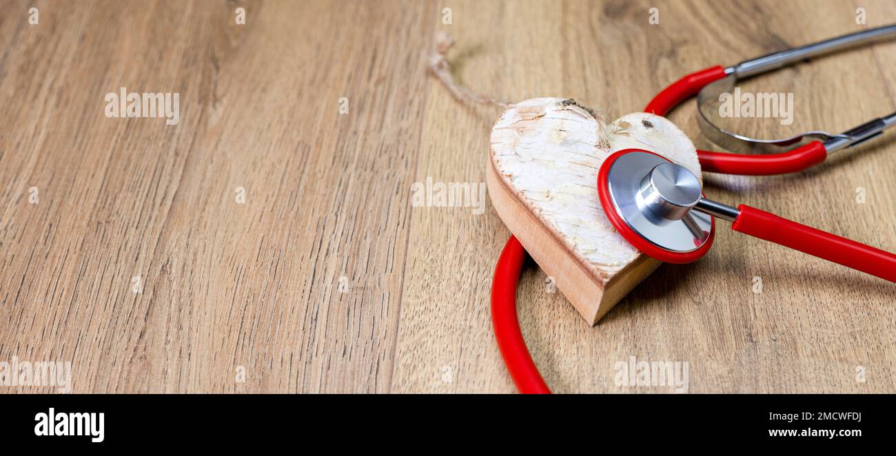 bannière ou stéthoscope rouge qui écoute le coeur du bois de bouleau blanc Banque D'Images