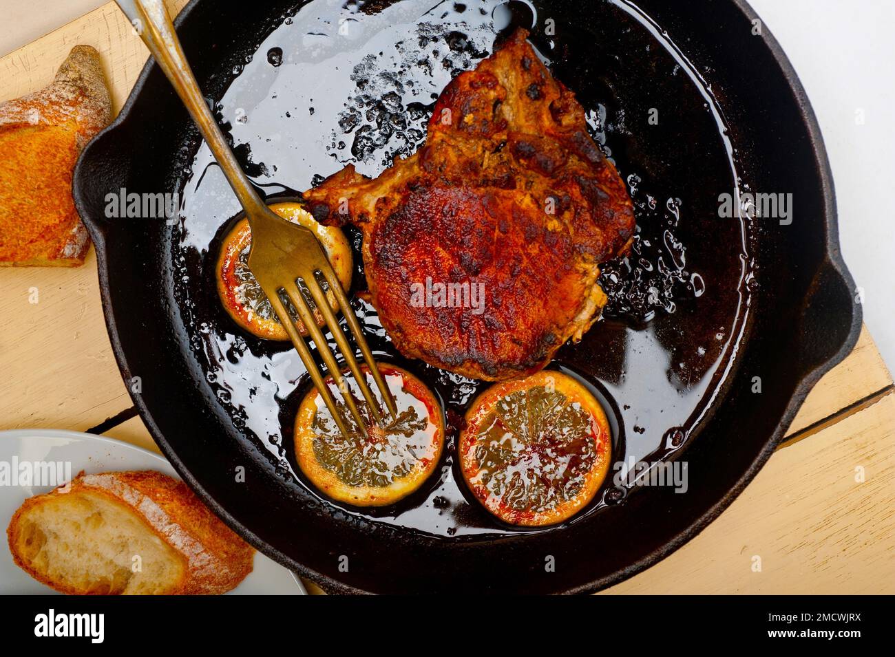 Hacher le porc saisi sur une poêle à repasser avec un assaisonnement au citron et aux épices Banque D'Images