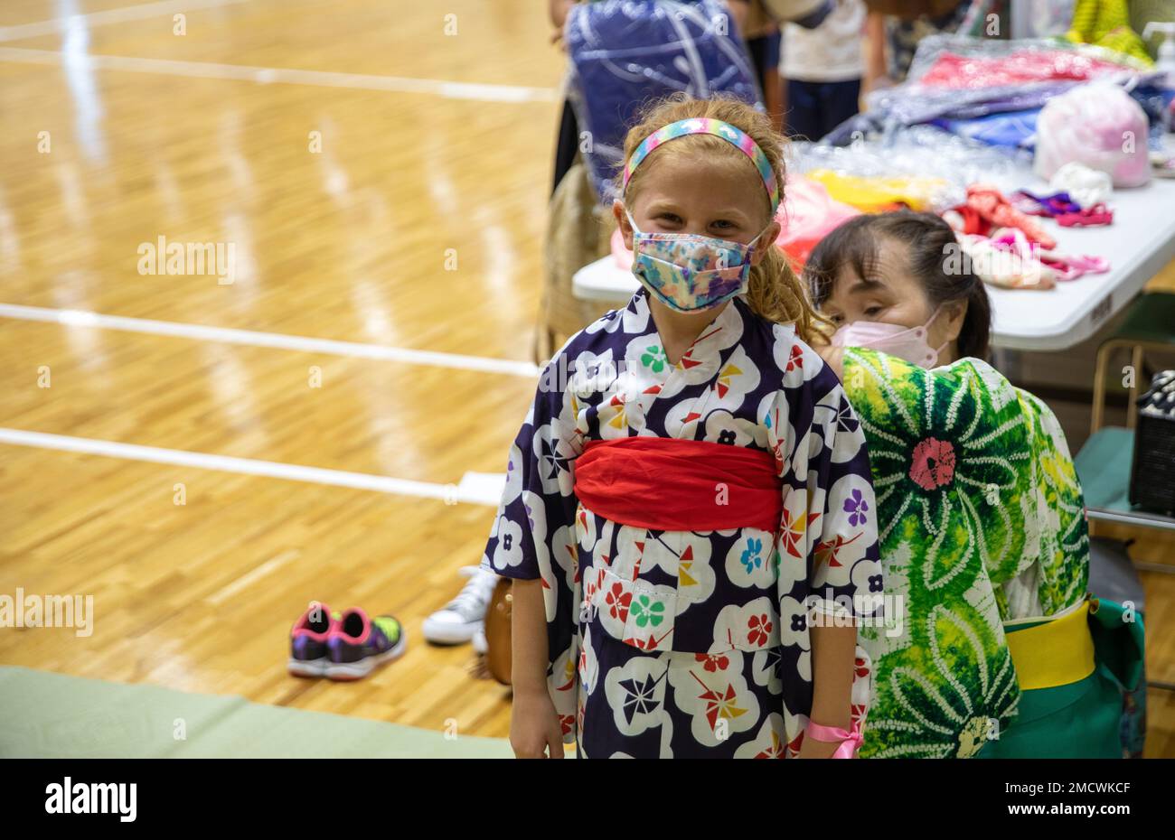 Un résident japonais aide à ajuster le kimono d’un enfant lors du Festival des étoiles de Tanabata à Iwakuni, Japon, 10 juillet 2022. Le Tanabata Star Festival, originaire de Chine, remonte à des milliers d'années; les gens célèbrent aujourd'hui le festival en accrochant leurs souhaits manuscrits sur des bambous, et en accueillant la saison d'été. Ces événements, organisés par la Marine corps Air Station Iwakuni Japanese American Society, ont pour but de présenter aux membres DE SOFA les déguisements, les jeux et les coutumes traditionnels japonais, ce qui renforce encore davantage les liens entre les locaux américains et japonais. Banque D'Images