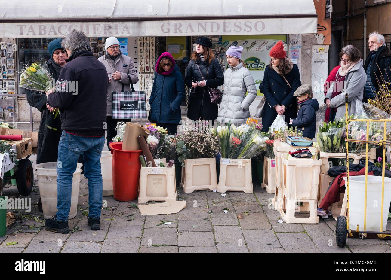 21 janvier 2023. Les Italiens vêtus de vêtements d'hiver font la queue dans une fleur dans un marché sur une piazza dans le centre de Venise. Banque D'Images