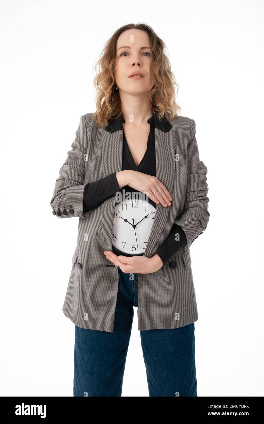 Une femme tient une montre sur son ventre. Grossesse, menstruation, concept d'horloge biologique. Isolé sur blanc Banque D'Images