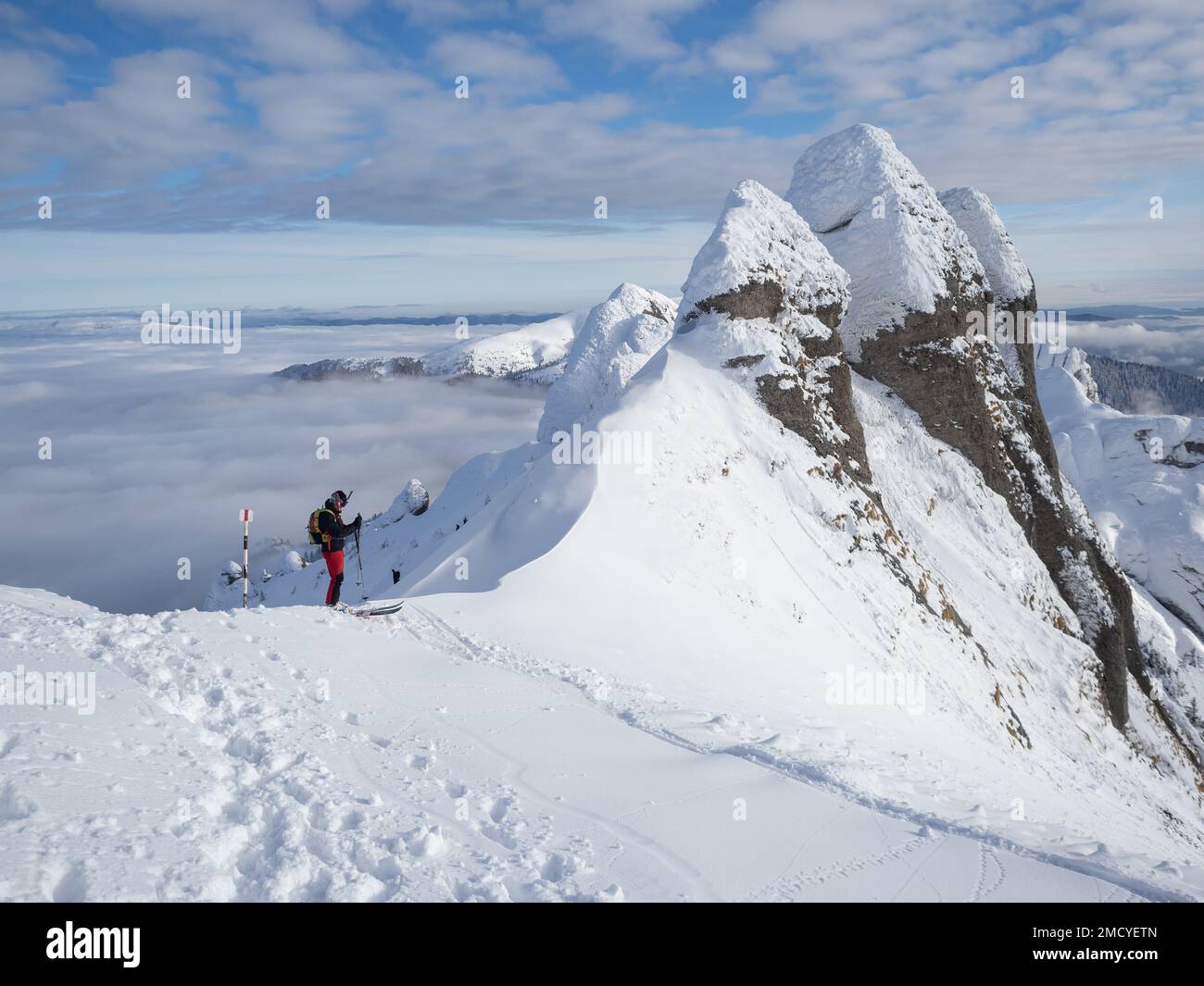 Skieur solitaire dans les hautes montagnes. Ski acrobatique extrême dans la lumière du soleil sur le paysage de montagne d'hiver Banque D'Images