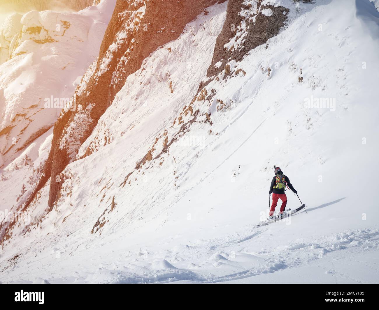 Skieur solitaire dans les hautes montagnes. Ski acrobatique extrême dans la lumière du soleil sur le paysage de montagne d'hiver Banque D'Images