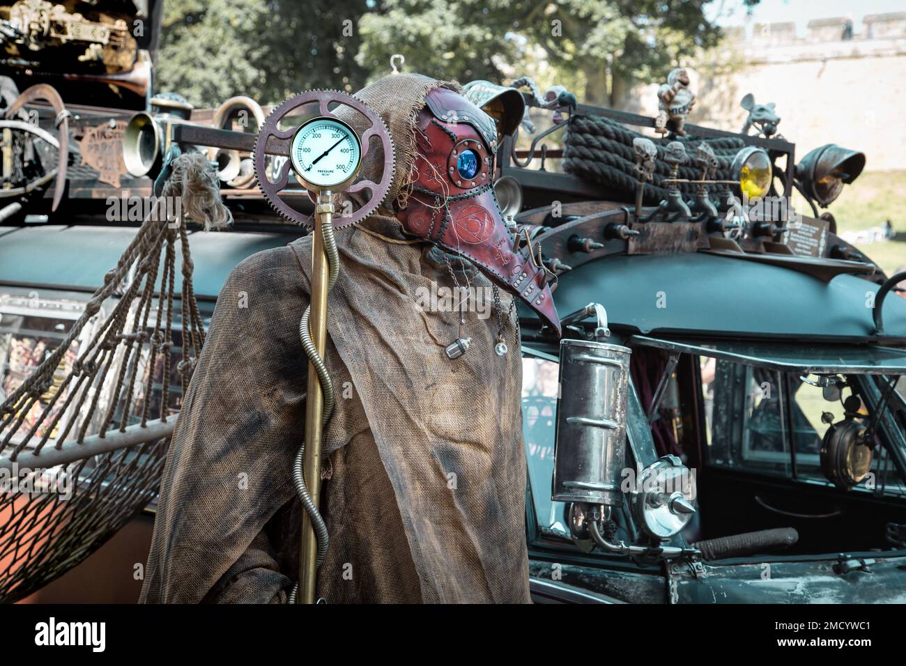 Une figure portant un masque de peste debout devant un véhicule. Post apocalyptique ou dystopique thème. Banque D'Images