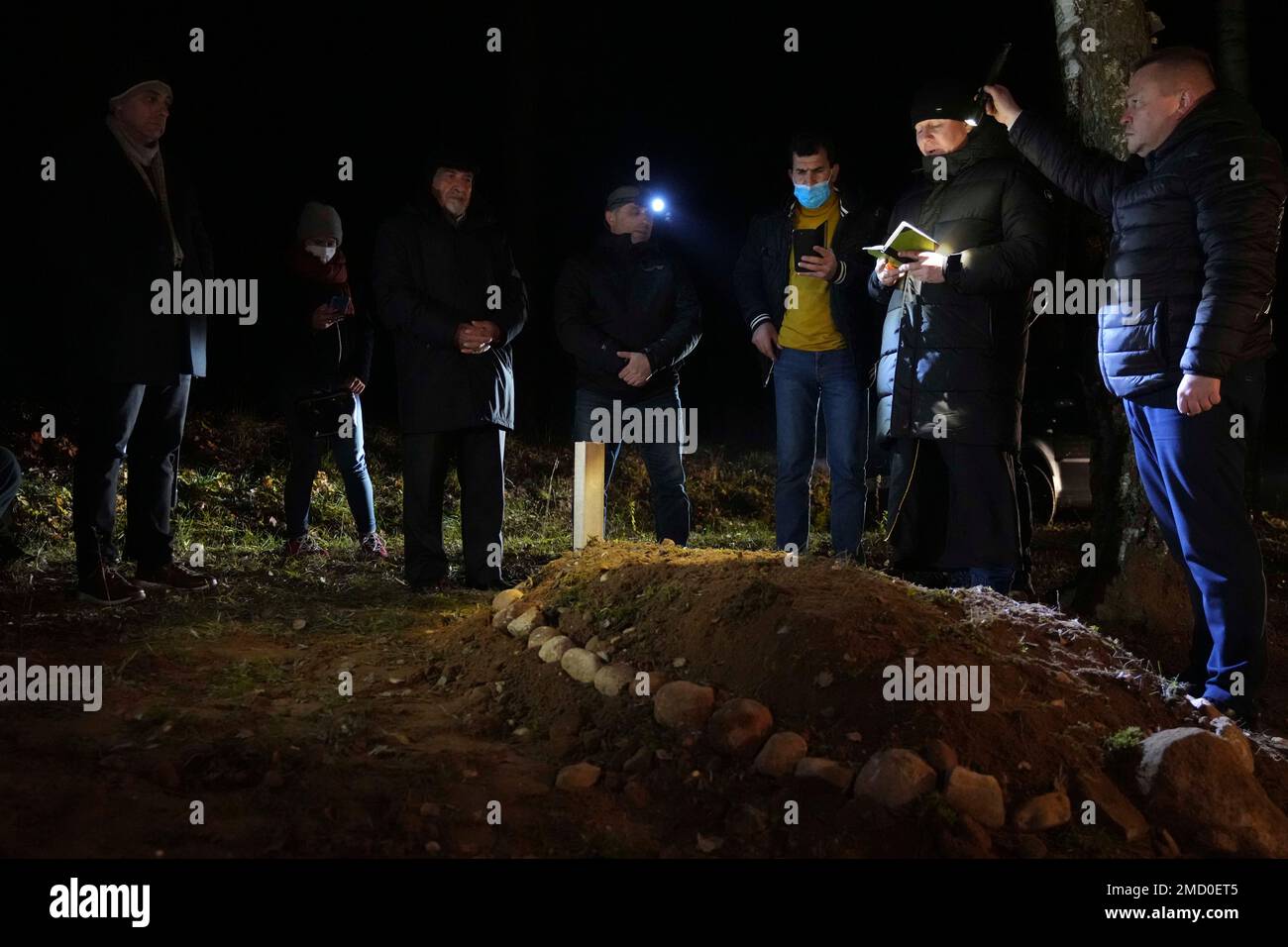 People of a Muslim congregation community pray at the grave of young Syrian man, Ahmad al-Hassan in Bohoniki near Sokolka, Poland, Monday, Nov. 15, 2021. The 19-year-old man died in late October in a river in this freezing, forested buffer zone where thousands of migrants and asylum seekers have been sent by the Belarus government to try to break through into Poland and the European Union. (AP Photo/Matthias Schrader) Banque D'Images