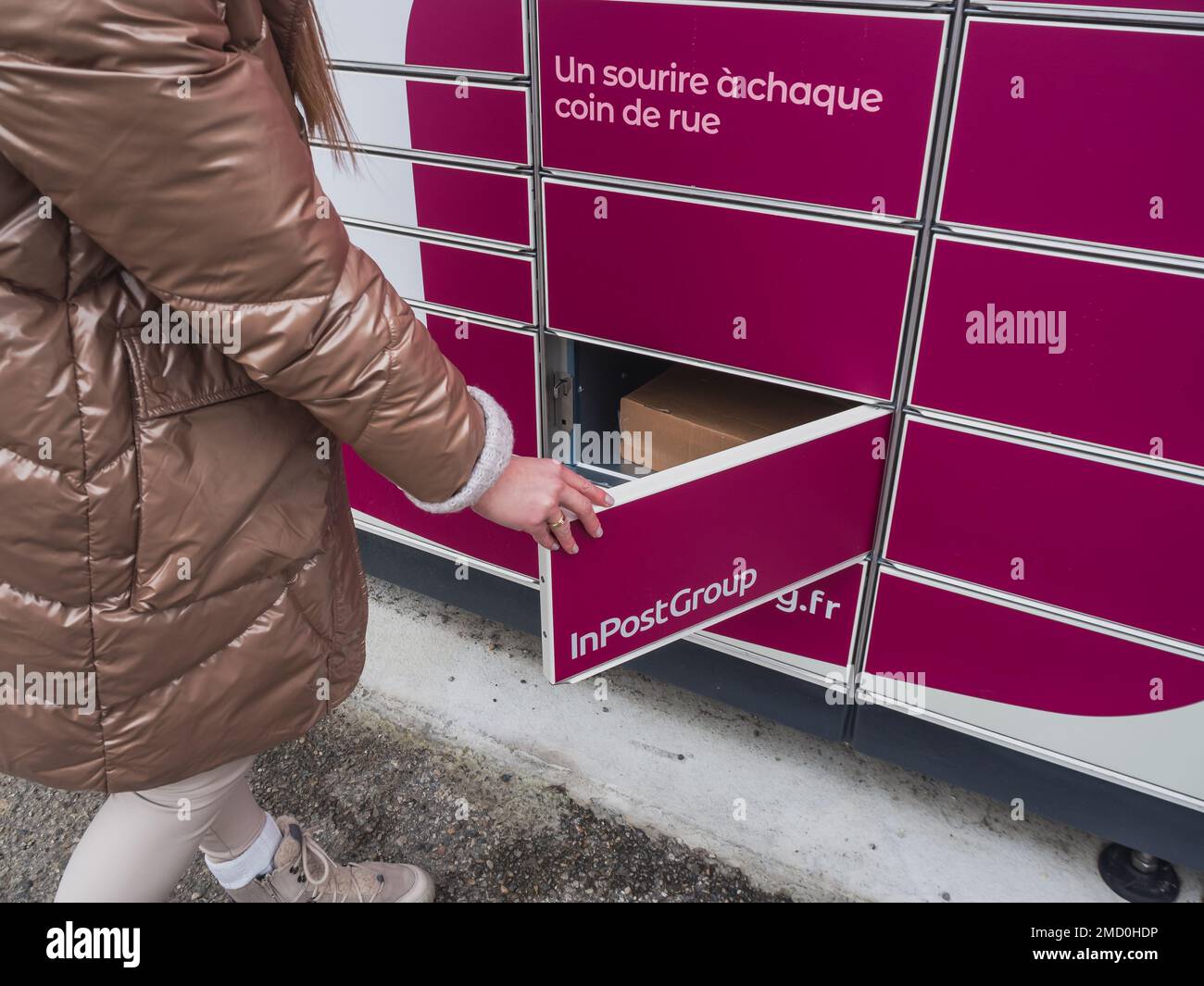 Loriol sur Drome, France - 14 janvier 2023: Enlèvement d'une parcelle d'un mondial "Relais casier par une jeune femme. Relais mondial de casiers. Caisse de pick-up. Banque D'Images