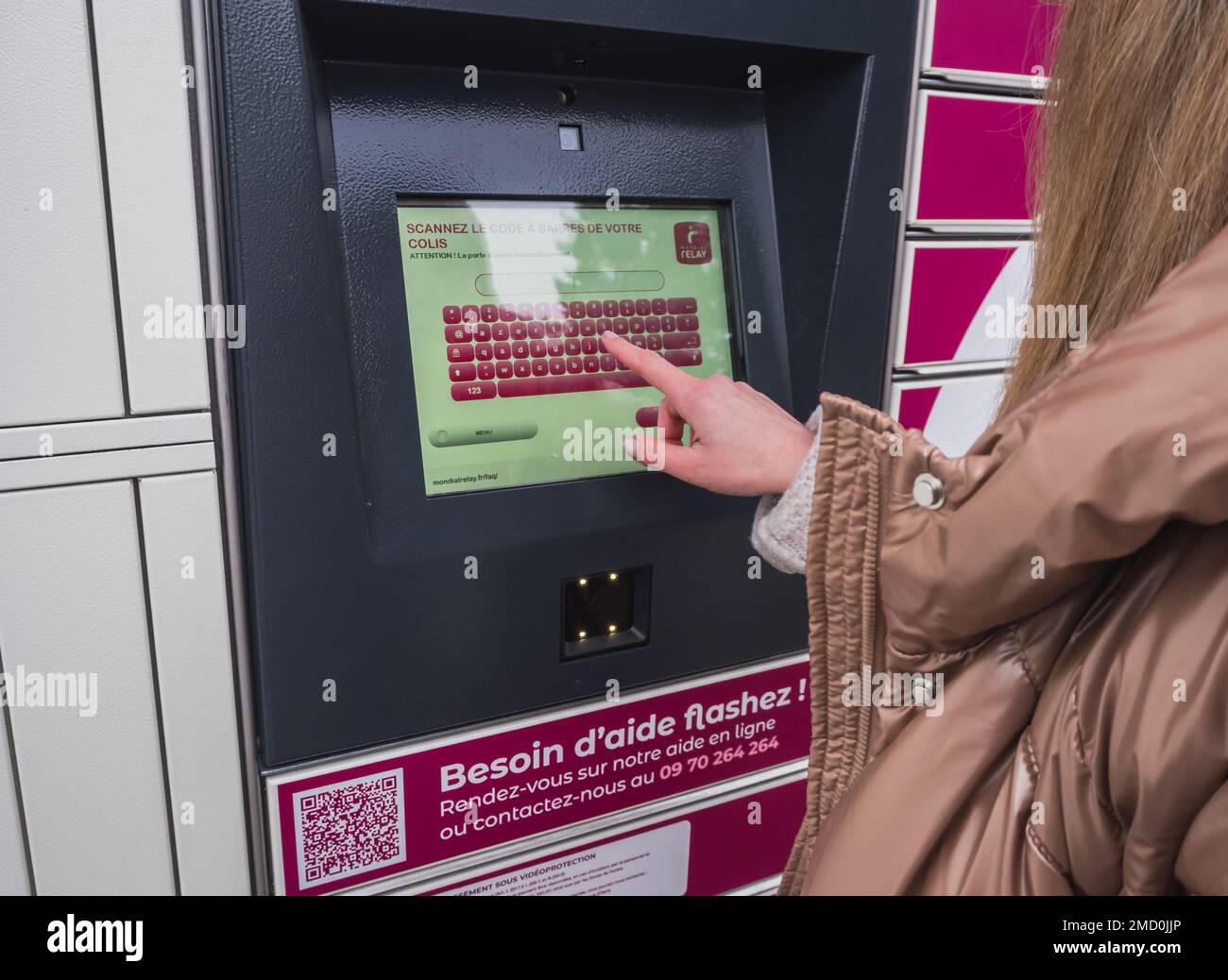 Loriol sur Drome, France - 14 janvier 2023: Enlèvement d'une parcelle d'un mondial "Relais casier par une jeune femme. Relais mondial de casiers. Caisse de pick-up. Banque D'Images