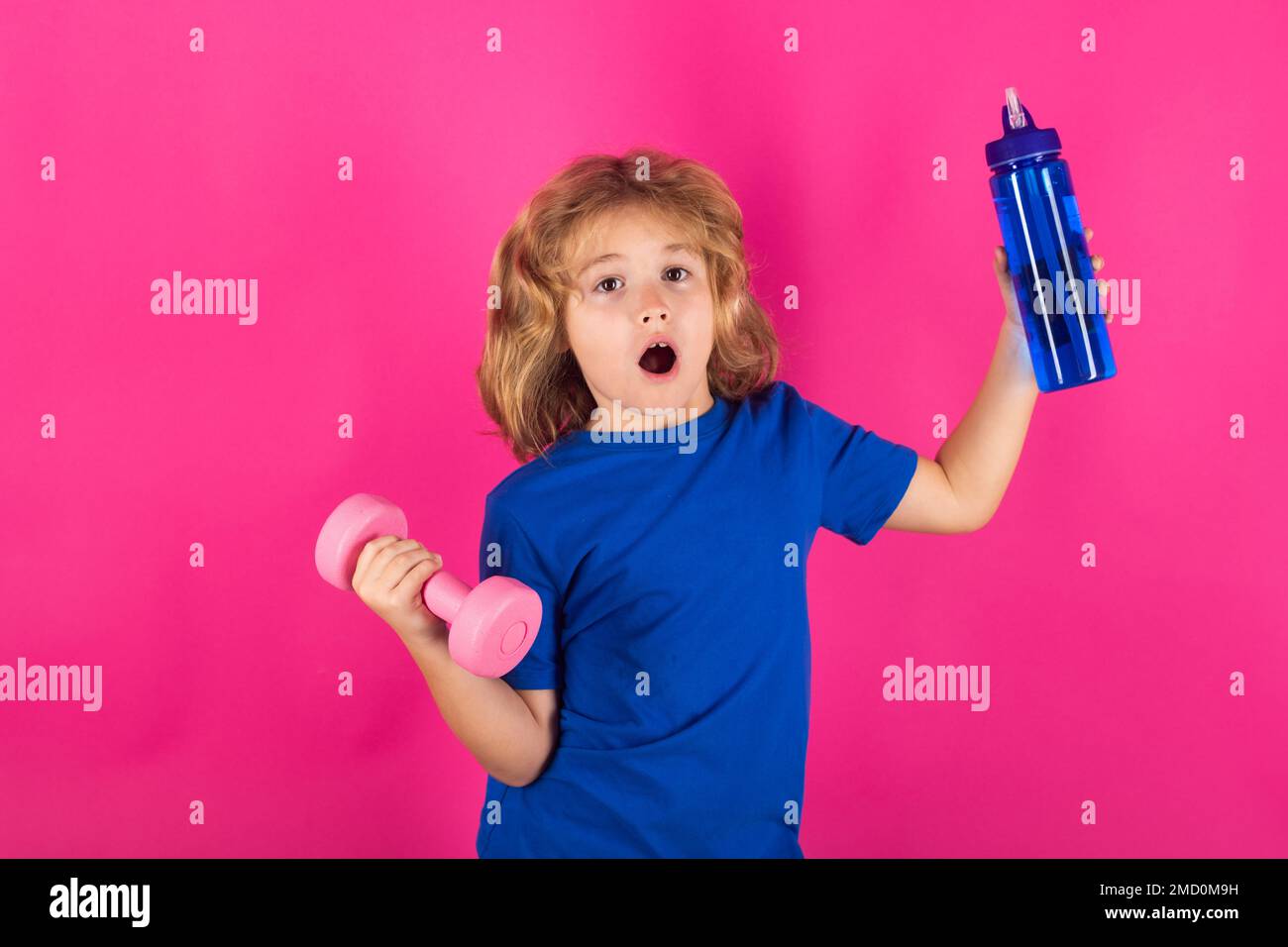 Enfants sportifs, portrait isolé en studio sur fond rouge rose. Activités sportives à loisir avec les enfants. Garçon blond tenant des haltères. Sports Banque D'Images