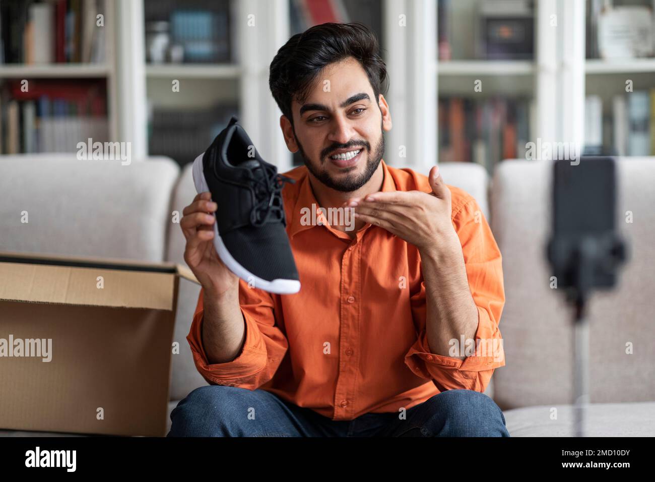 Beau blogueur de mode de type arabe montrant de nouvelles chaussures Banque D'Images