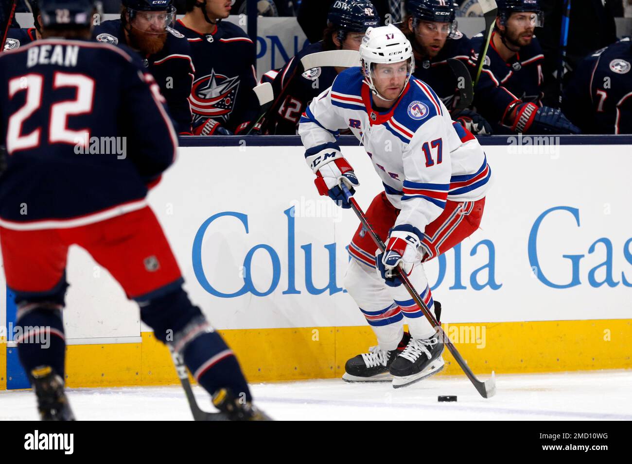 New York Rangers forward Kevin Rooney, right, controls the puck in front of Columbus Blue Jackets defenseman Jake Bean during an NHL hockey game in Columbus, Ohio, Saturday, Nov. 13, 2021. The Rangers won 5-3. (AP Photo/Paul Vernon) Banque D'Images