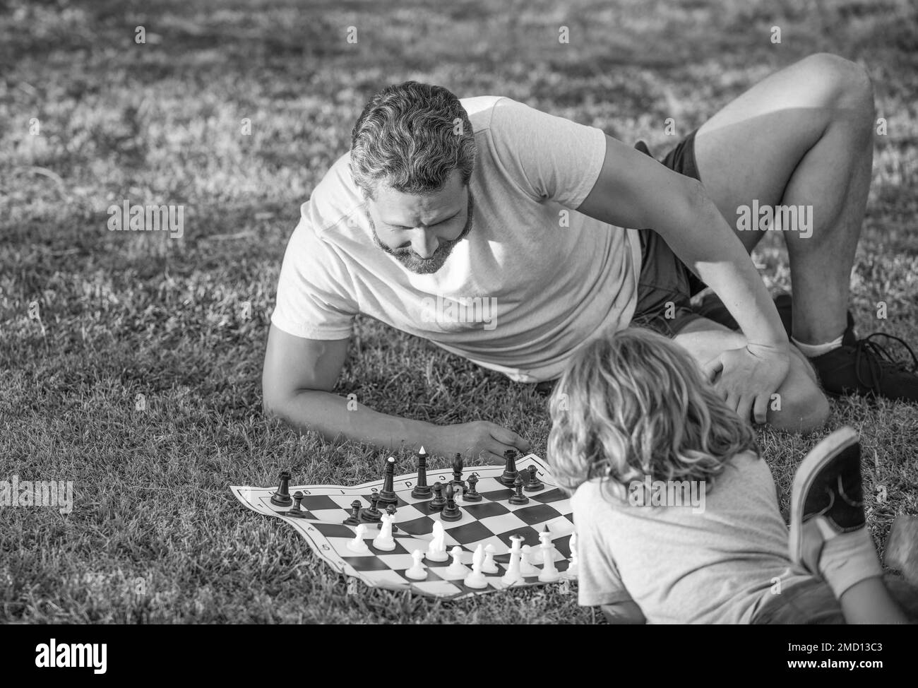 passer du temps ensemble. stratégique et tactique. tutelle. papa et l'enfant jouent à un jeu logique. père et fils jouant aux échecs sur l'herbe dans le parc. fête des pères. immo Banque D'Images