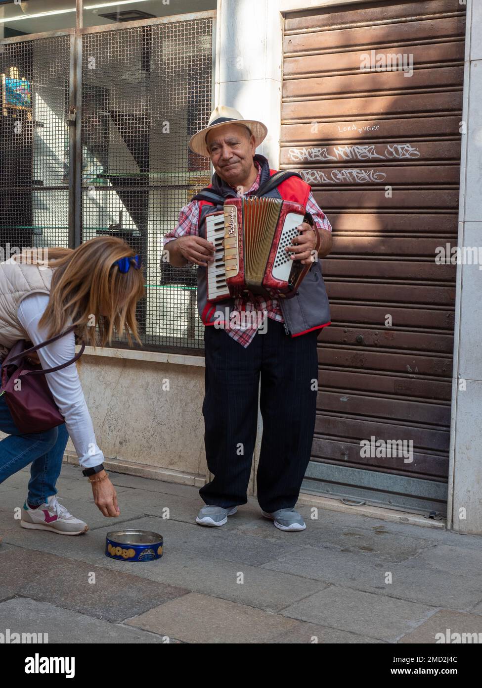 31 octobre 2022 - Venise, Italie : une femme donne de l'argent à un musicien dans la rue. Concept de musique. Banque D'Images