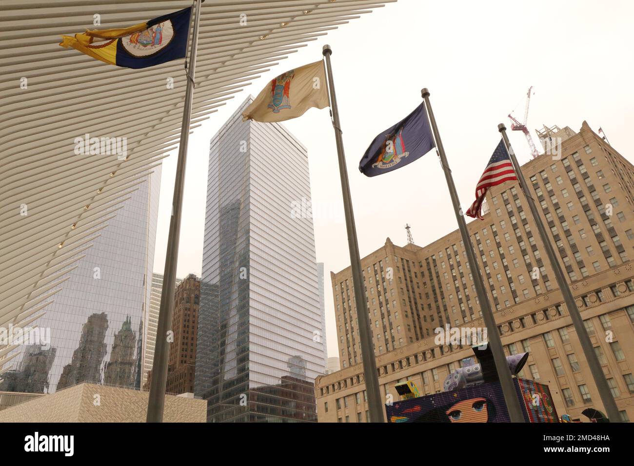 Drapeaux New-yorkais sous l'aile de l'Oculus White colombe comme structure avec le Federal Office Building en arrière-plan. Entrée au World Trade Center. Banque D'Images
