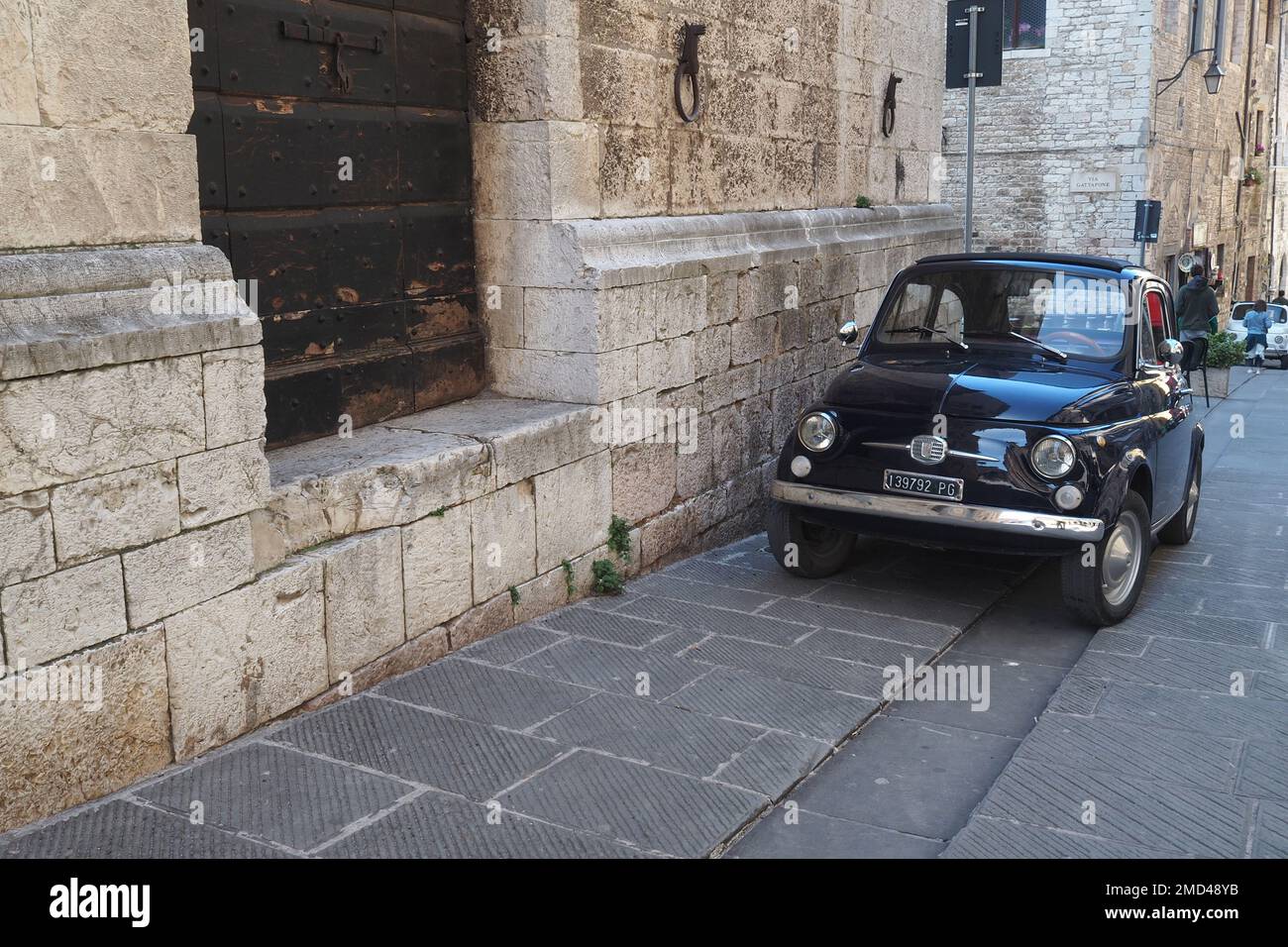 Voiture italienne emblématique 'Fiat 500' garée dans le village médiéval de Gubbio, région de l'Ombrie, Italie Banque D'Images