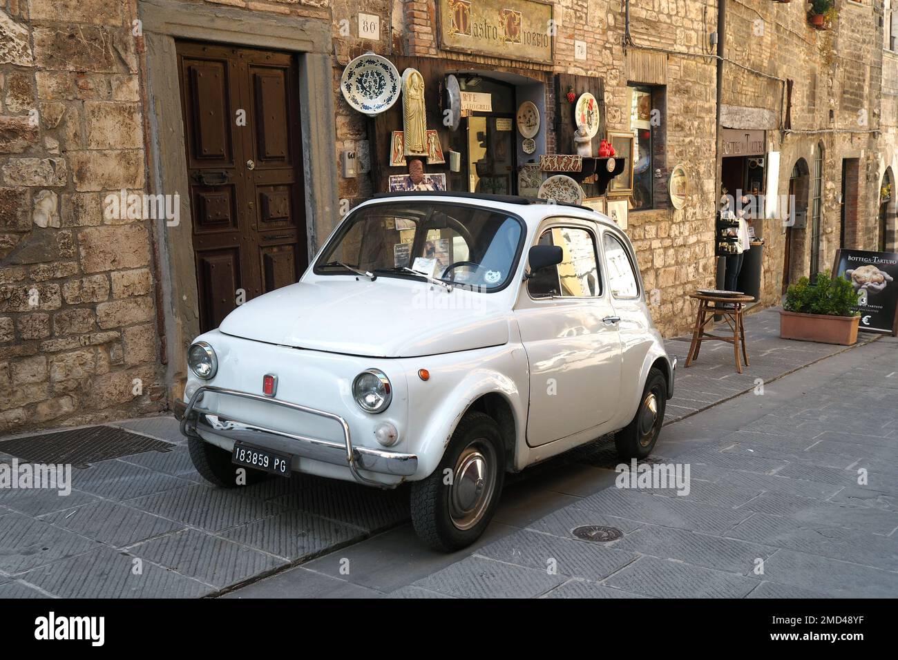 Voiture italienne emblématique 'Fiat 500' garée dans le village médiéval de Gubbio, région de l'Ombrie, Italie Banque D'Images